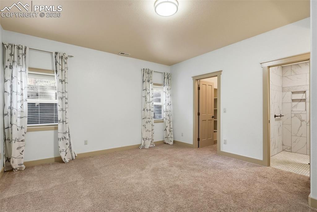 2nd bedroom with light colored carpet and baseboards
