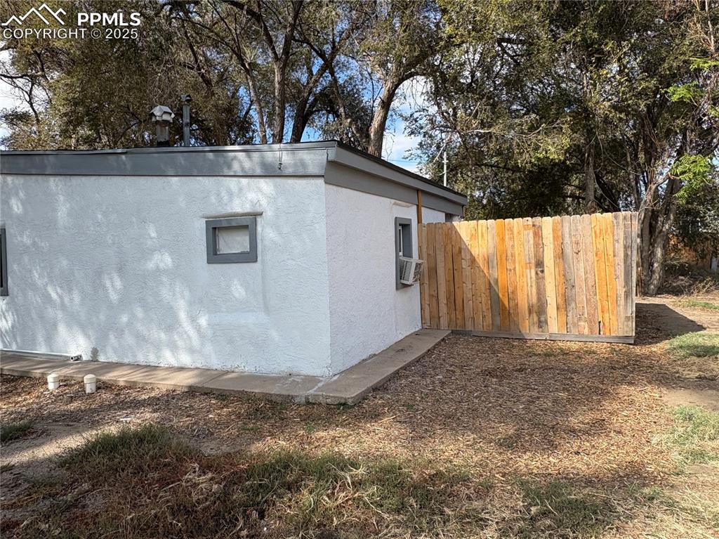 View of side of property with stucco siding and cooling unit