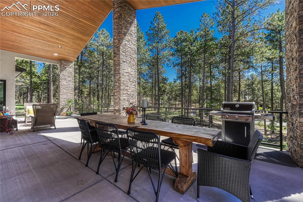 View of patio with outdoor dining area and grilling area