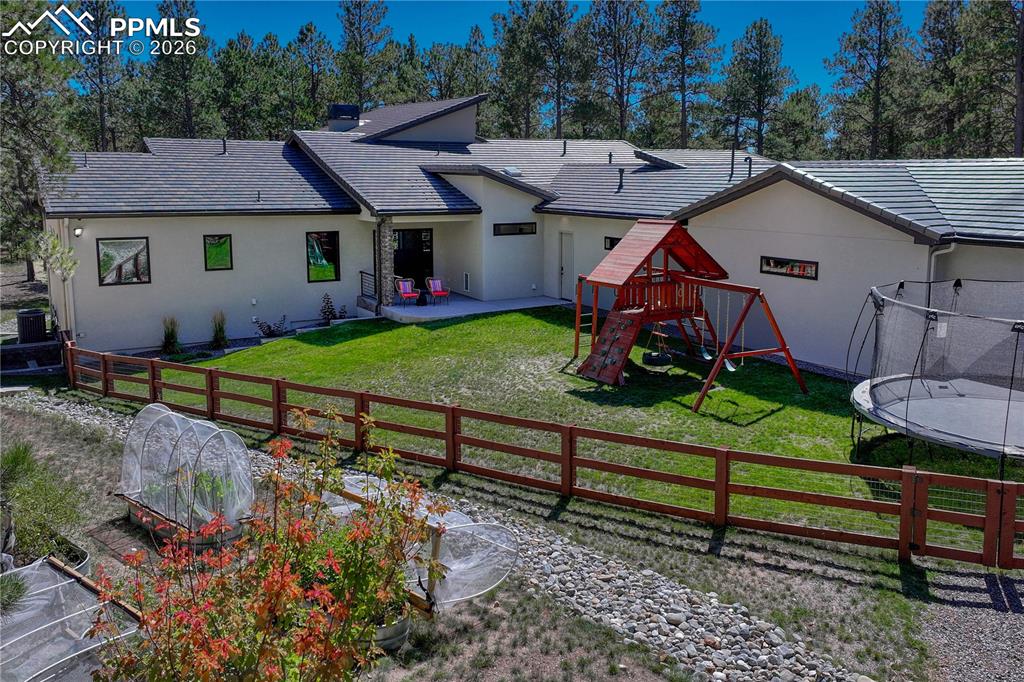 Back of property featuring stucco siding, a patio area, a lawn, and a balcony