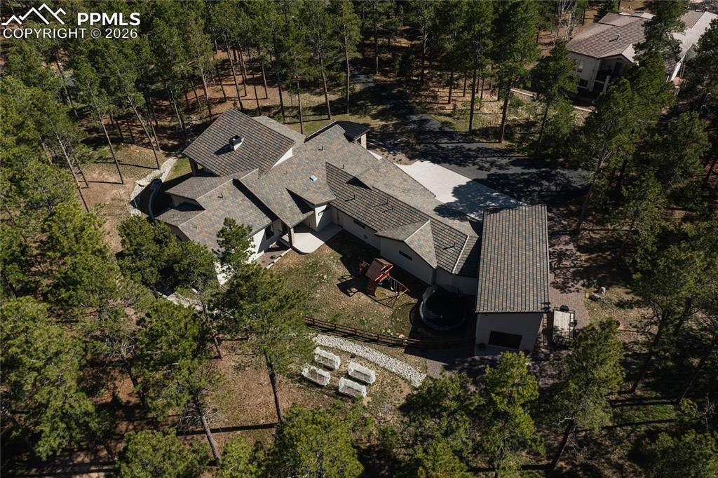 View of subject property with a tree filled landscape