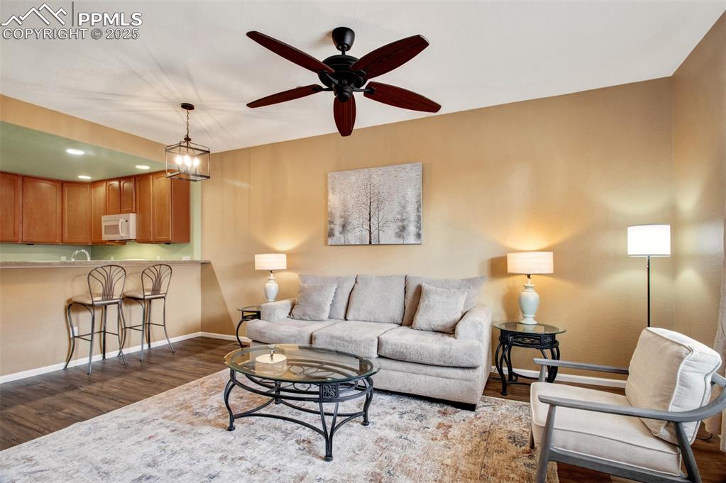 Another view of the living room featuring new flooring and all furnishings, ceiling fan, and recessed lighting