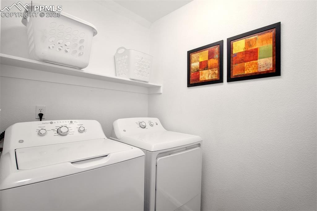 Main level laundry area with washer and clothes dryer that are included