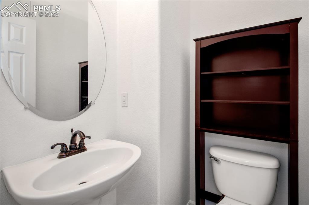 Guest half bathroom featuring a sink and toilet on the main level