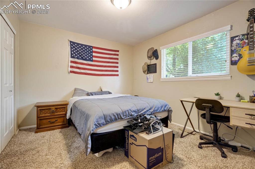 Carpeted bedroom featuring a closet and baseboards