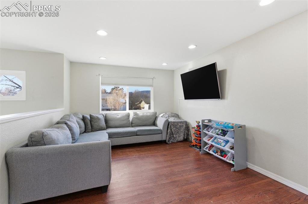 Living area featuring dark wood-type flooring and recessed lighting
