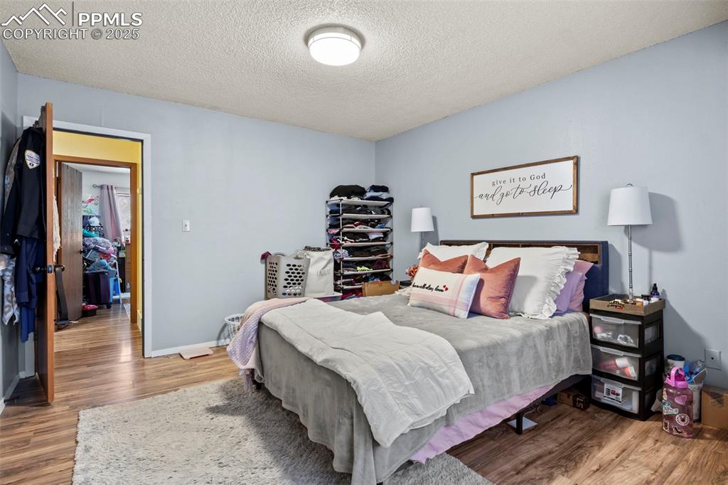Bedroom featuring a textured ceiling and wood finished floors