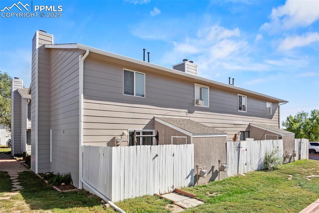 Back of property featuring a chimney and a gate