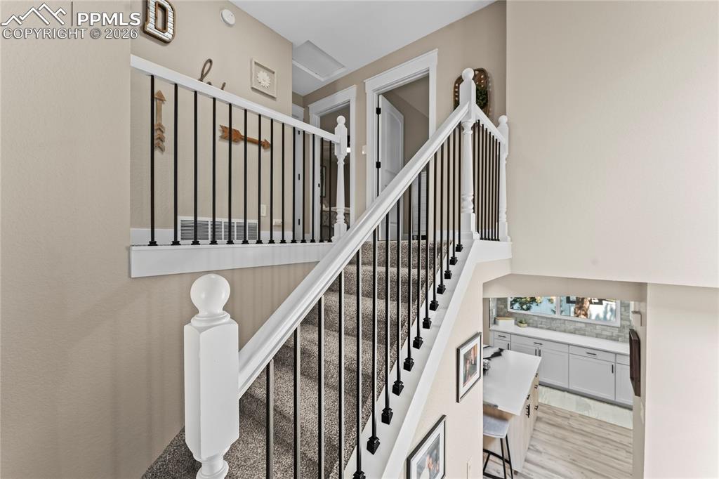 Stairway featuring wood finished floors