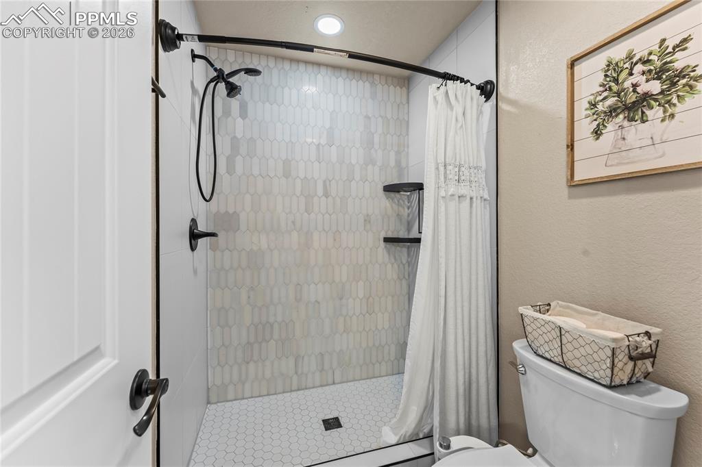 Full bathroom with a stall shower and a textured wall