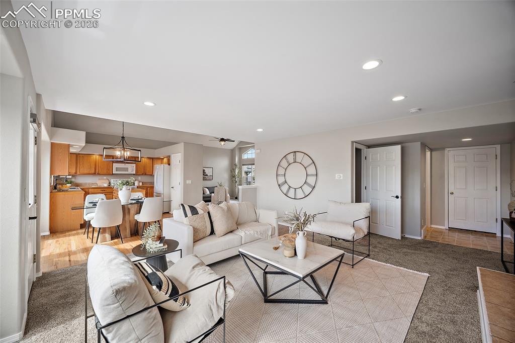 Living area featuring light colored carpet and a chandelier