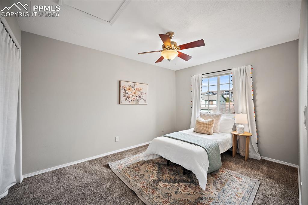 Carpeted bedroom featuring baseboards and a ceiling fan