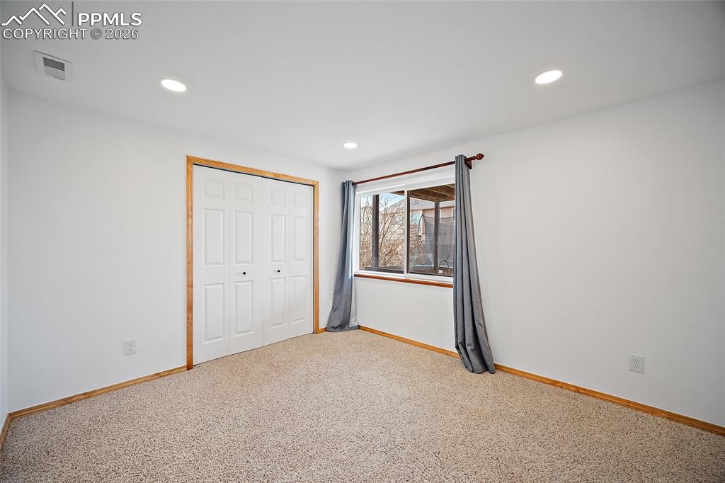Unfurnished bedroom featuring light colored carpet, a closet, and recessed lighting