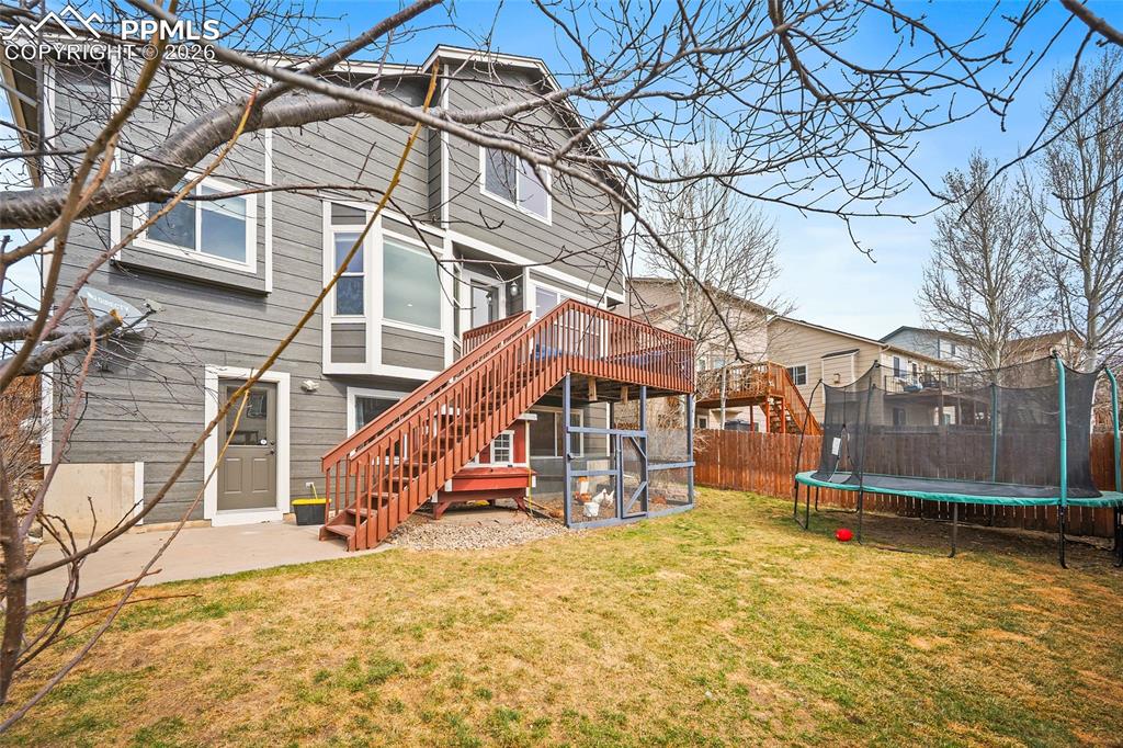Back of house featuring a trampoline and a patio area
