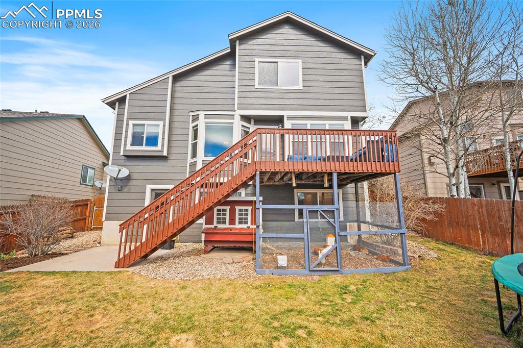 Back of house with a fenced backyard and a wooden deck