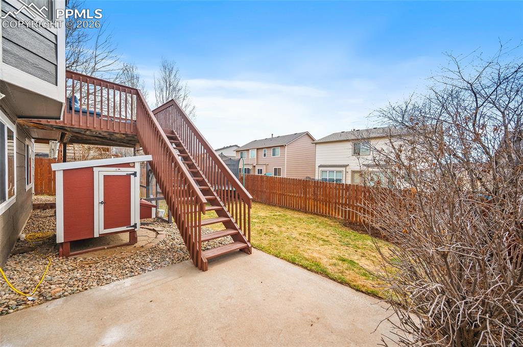 Fenced backyard featuring a patio area, a residential view, and a deck