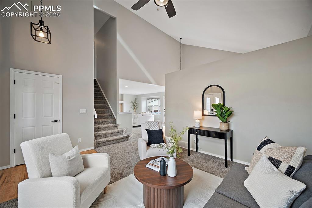 Living room with lofted ceiling and ceiling fan