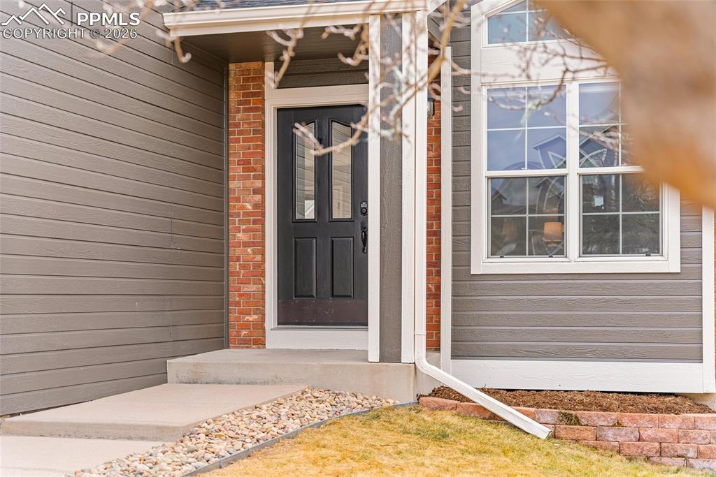 Entrance to property featuring brick siding