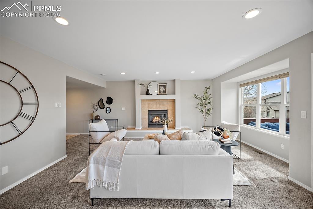 Carpeted living room featuring recessed lighting and a fireplace