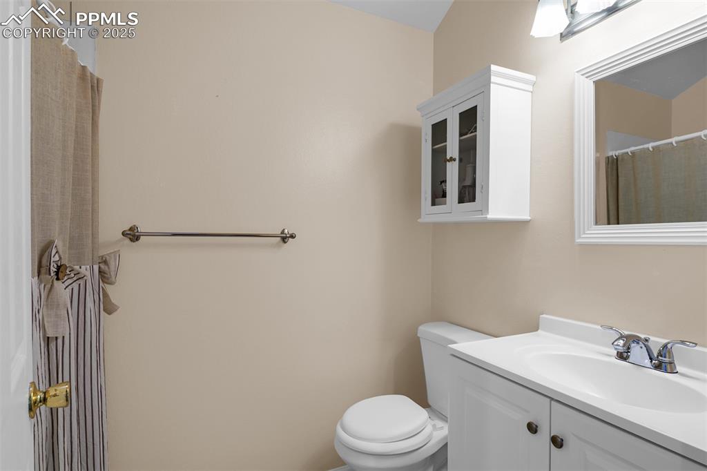 3/4 bathroom on upper level adjacent to bedroom 1 featuring curtained shower and vanity