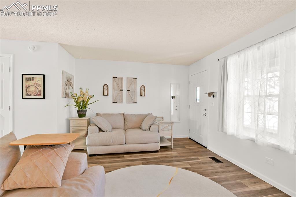 Another view of the Living area with a textured ceiling and wood finished floors