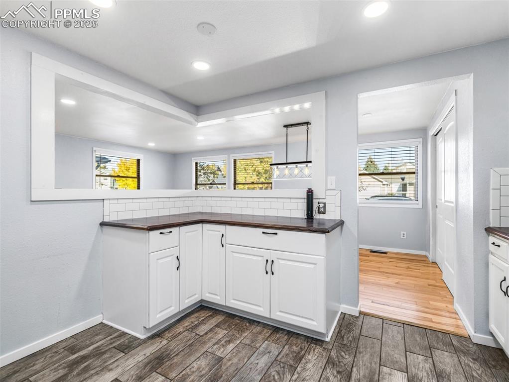 Kitchen with white cabinetry, dark wood finished floors, healthy amount of natural light, and recessed lighting