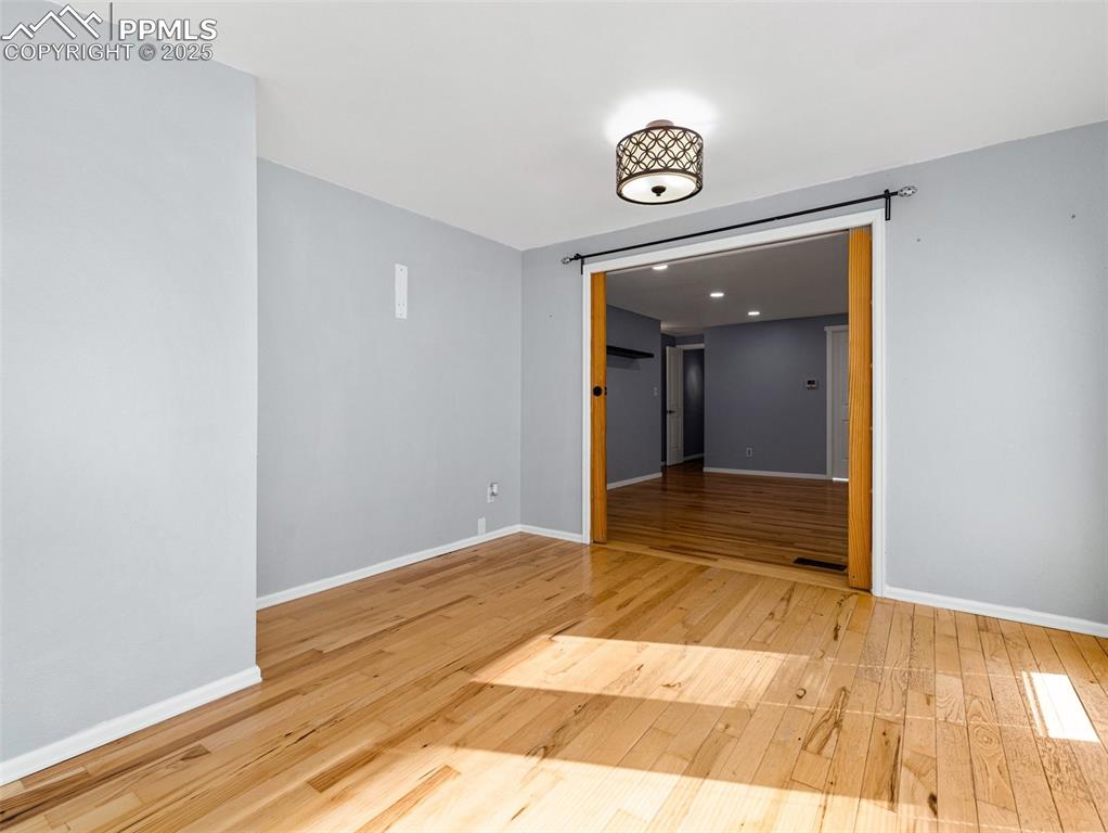 Unfurnished room featuring light wood-type flooring and baseboards