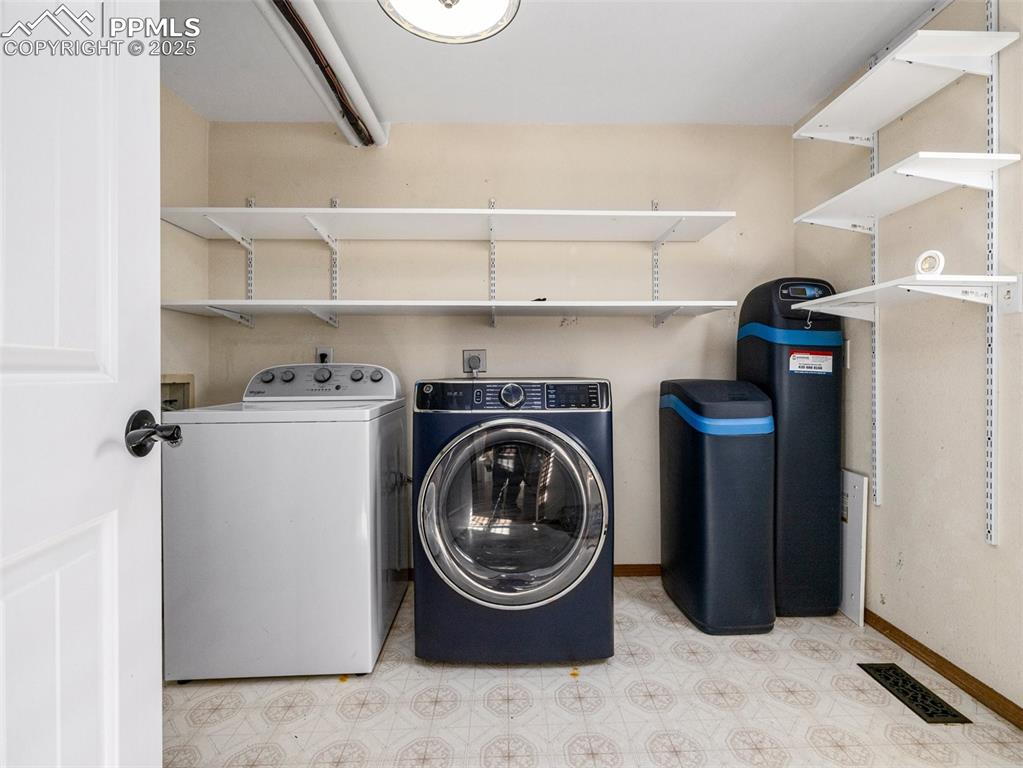Laundry area featuring tile patterned floors and washer and clothes dryer