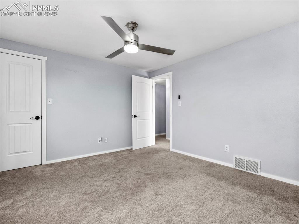 Unfurnished bedroom with carpet flooring and a ceiling fan