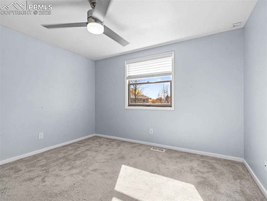 Spare room featuring carpet and ceiling fan