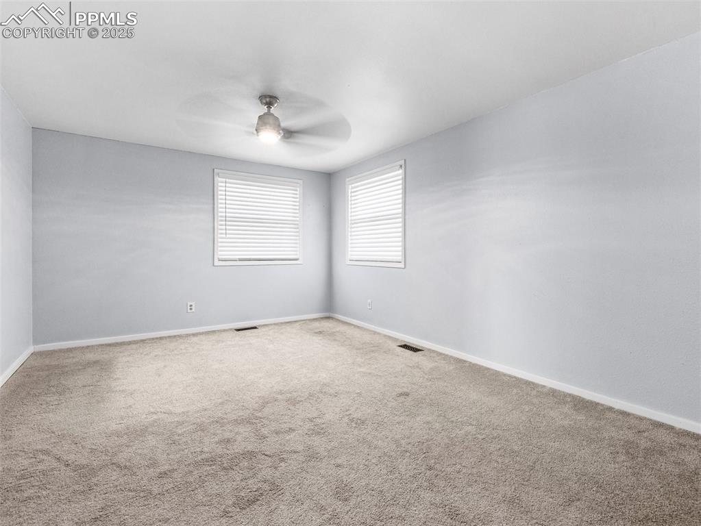 Empty room featuring carpet and a ceiling fan