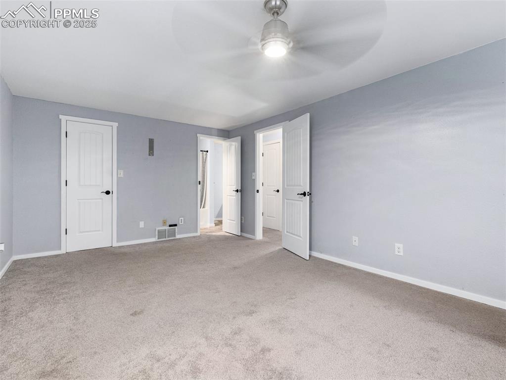 Unfurnished bedroom with carpet flooring and a ceiling fan