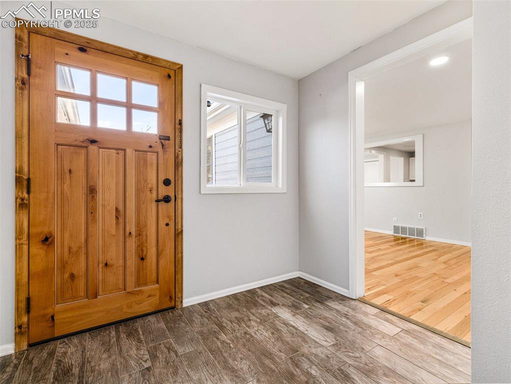 Entryway featuring dark wood-type flooring and baseboards