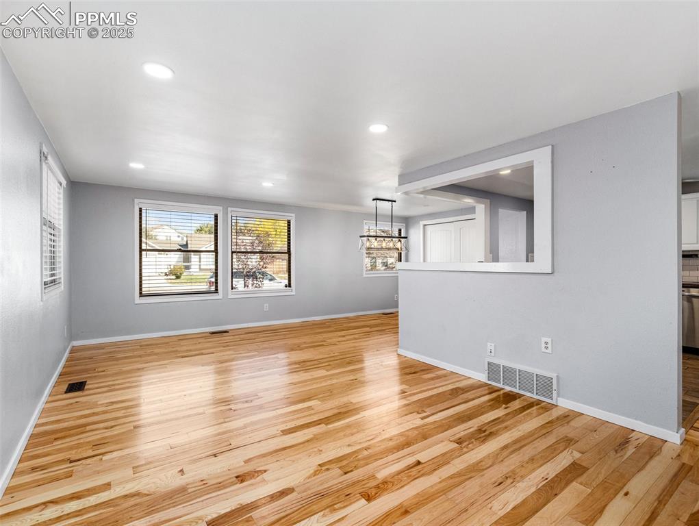 Empty room featuring light wood-style floors and recessed lighting