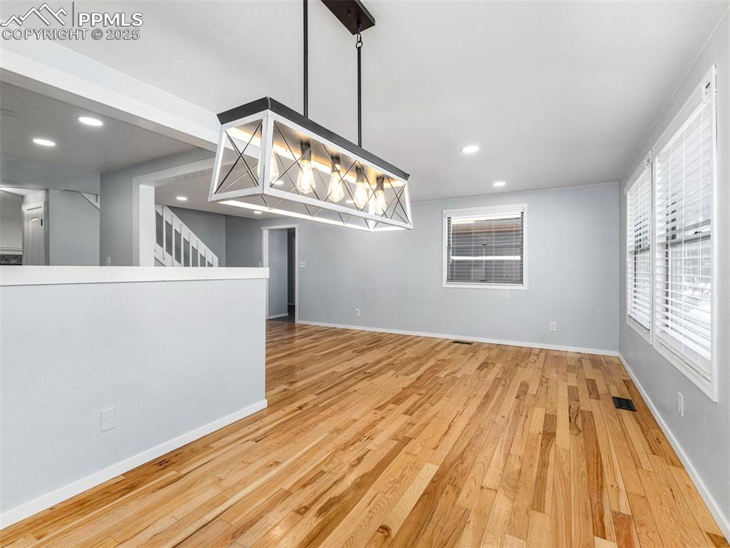 Unfurnished dining area with light wood-style flooring and recessed lighting