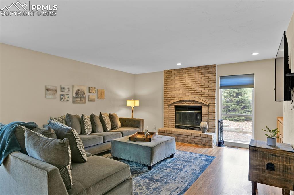 Living area featuring a fireplace, wood finished floors, and recessed lighting