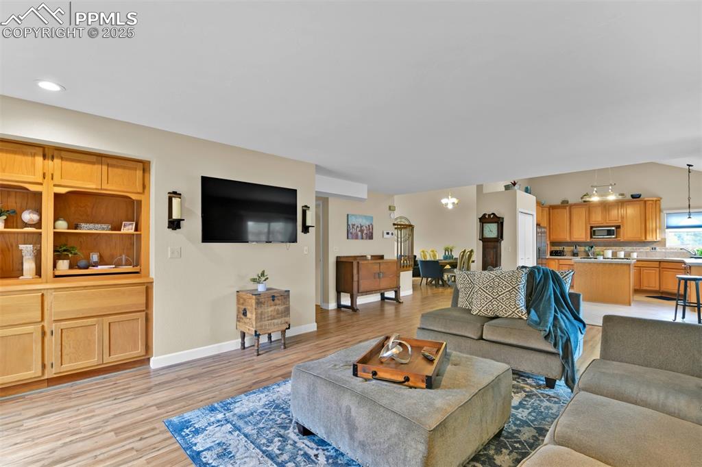 Living area featuring a chandelier, light wood-type flooring, and recessed lighting
