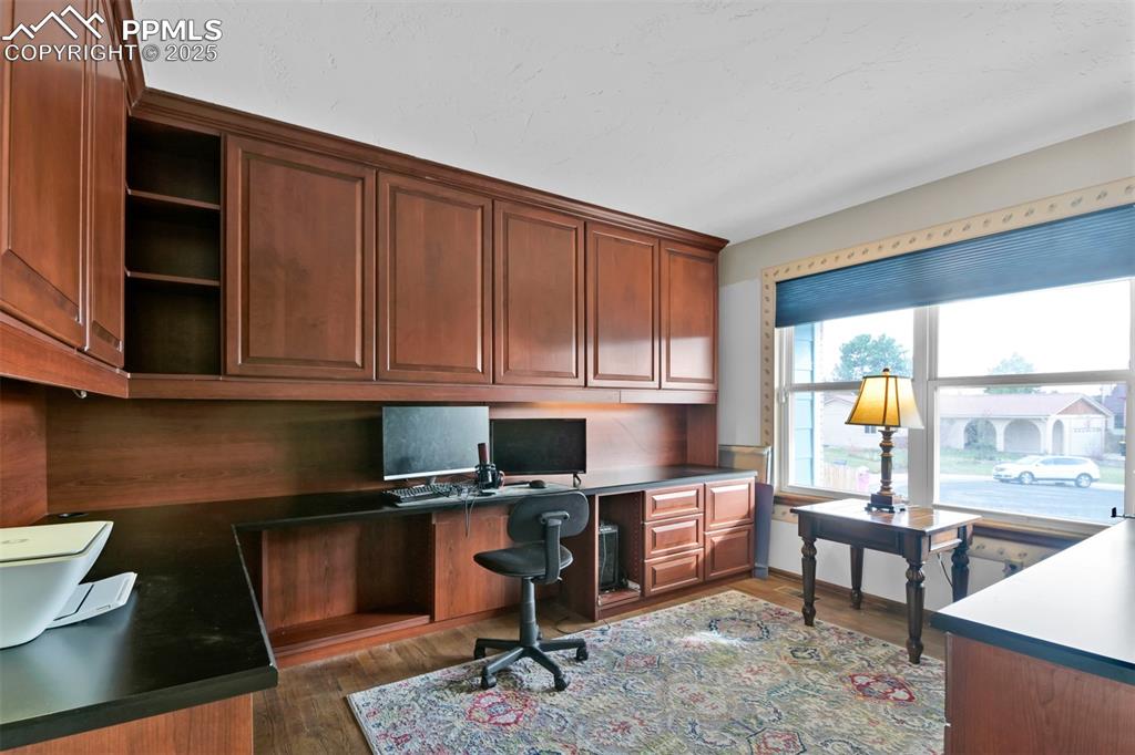 Home Office featuring wood finished floors and built in study area