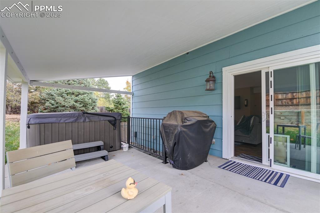 Deck with a hot tub and a grill