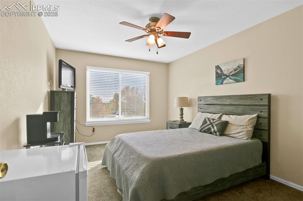 Carpeted bedroom featuring a ceiling fan