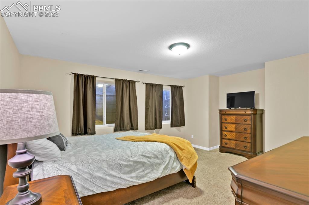 Bedroom with light colored carpet and a textured ceiling