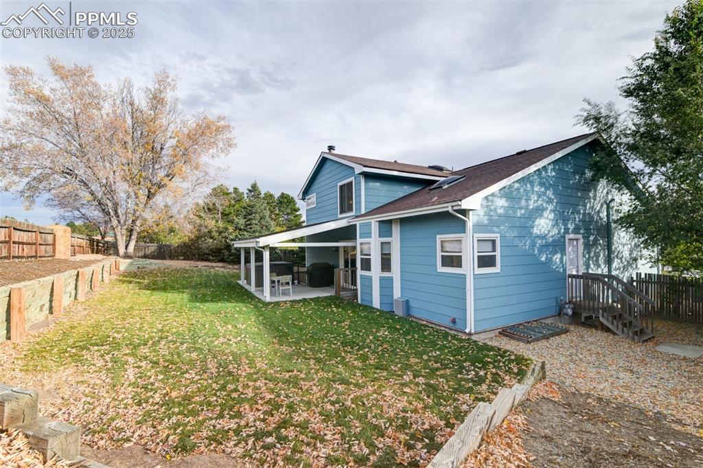 Back of house with a fenced backyard, a patio, and a shingled roof