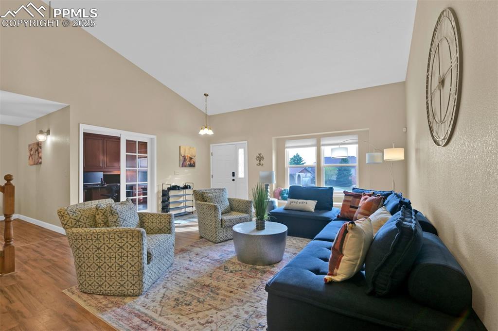 Living area featuring high vaulted ceiling and wood finished floors