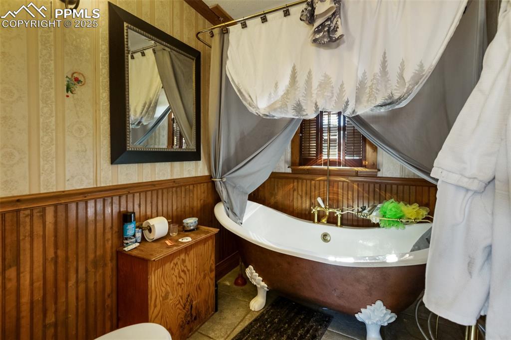 the upstairs bathroom is very thoughtfully arranged clawfoot tub and plenty of wood accents, the sink is a very high design placed just outside the main part of the bathroom