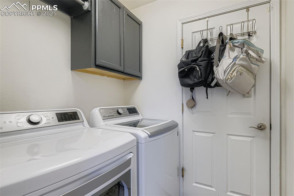 Washroom with cabinet space and washer and clothes dryer