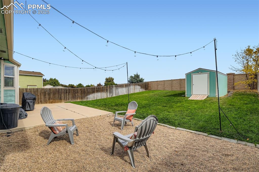 Fenced backyard with a patio area and a shed