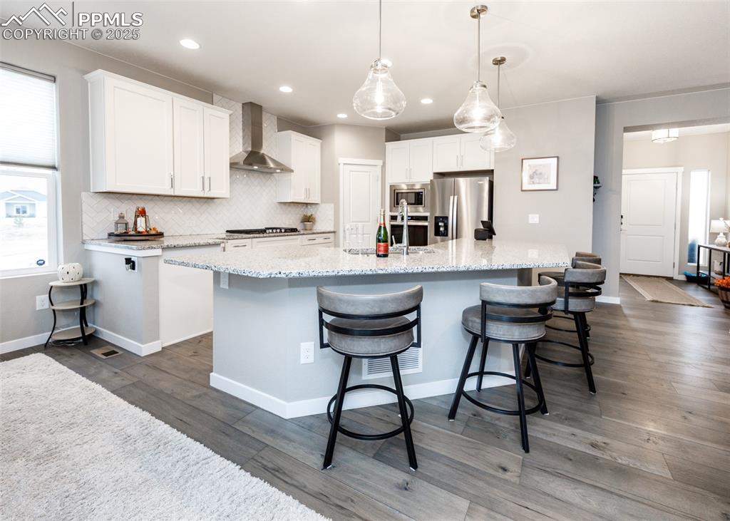 Stylish kitchen with white cabinetry, island, and decorative backsplash.