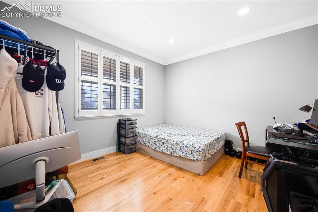 Bedroom with crown molding, light wood-style flooring, and recessed lighting