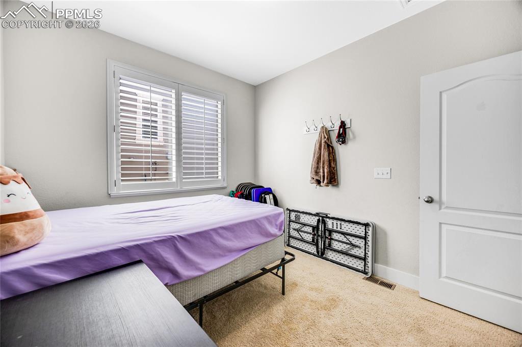 Bedroom with light colored carpet and baseboards