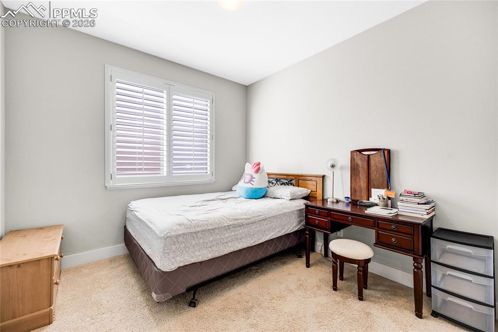 Bedroom with light colored carpet and baseboards